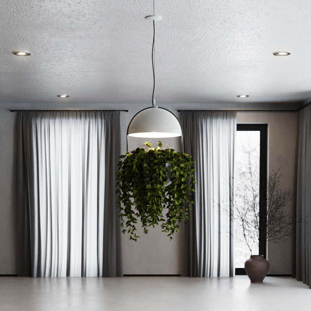 גוף תאורה תלוי LumiDome עם כיפת תאורה לבנה ועציץ גדול ממנו משתפלים ענפים ירוקים רבים; היחידה תלויה בחלל מודרני עם רצפת בטון, ווילונות ארוכים ואגרטל גדול בצד.